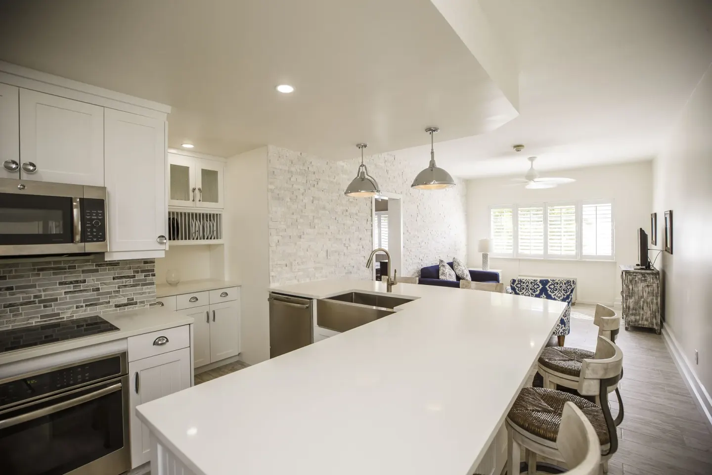 Suite kitchen with long island, bar stools, and living area at Ports of Call Resort.