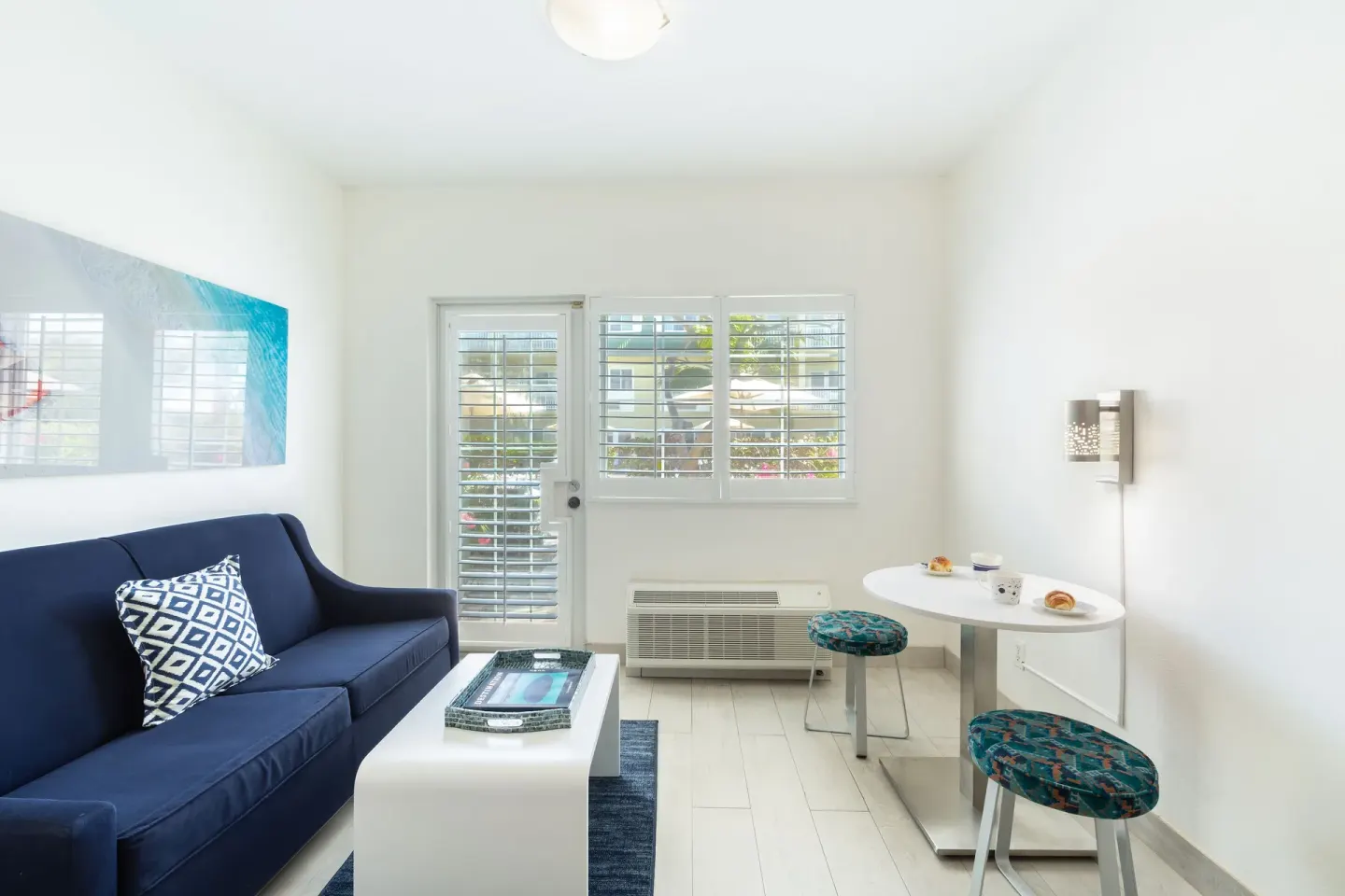 Suite sitting area with blue sofa, coffee table and bistro table at Ports of Call Resort.
