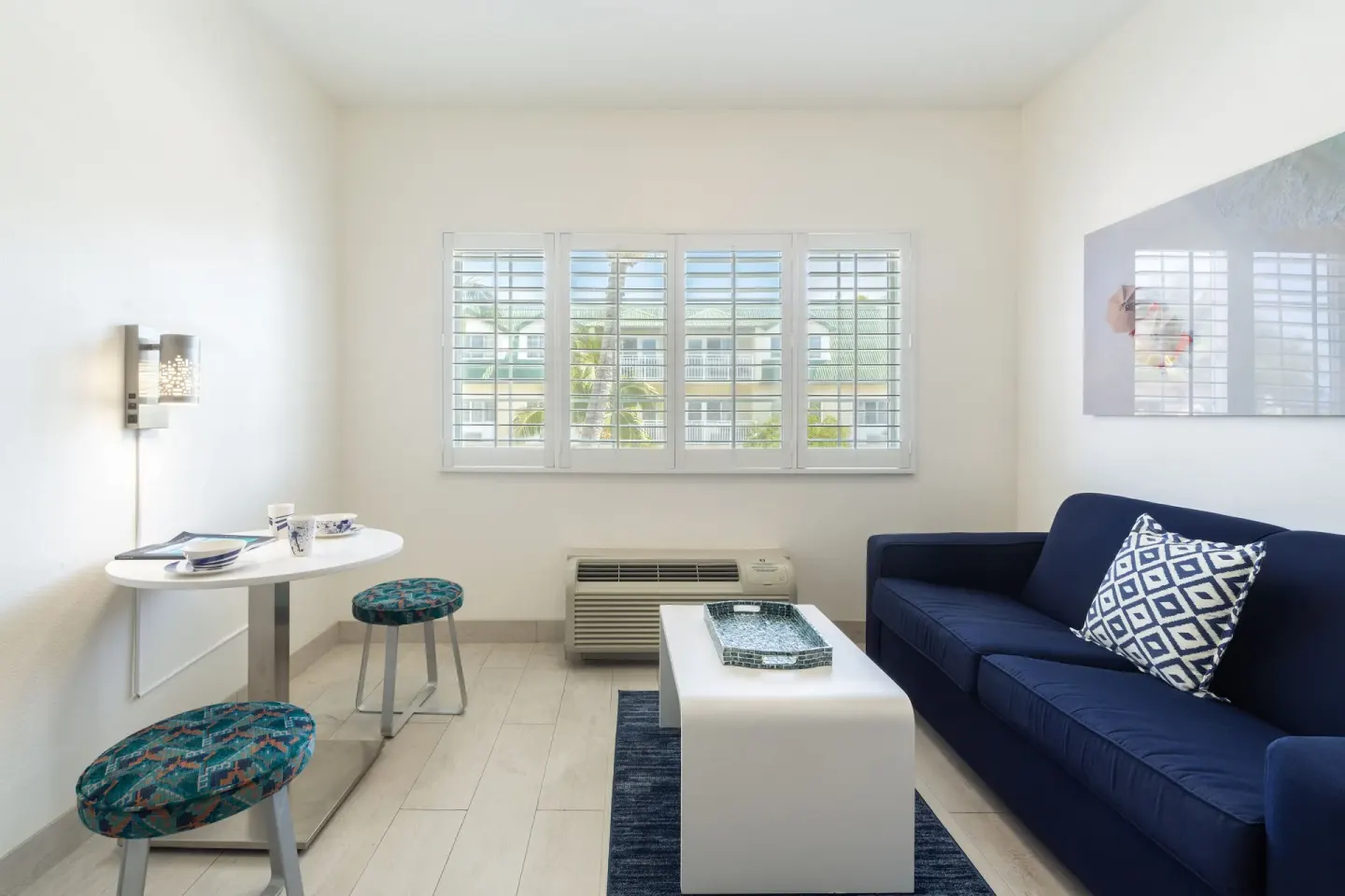 Suite sitting area with blue sofa and small dining table at Ports of Call Resort.