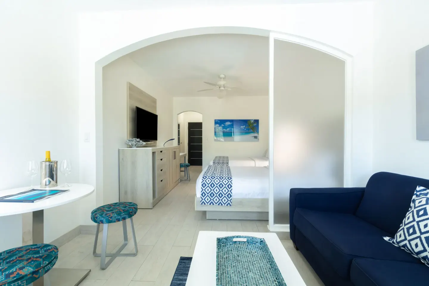 Suite-style guest room with sofa, bistro table, and king bed at Ports of Call Resort.