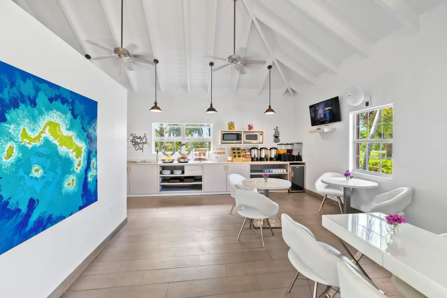 Bright breakfast room with white tables and buffet counter at Ports of Call Resort.