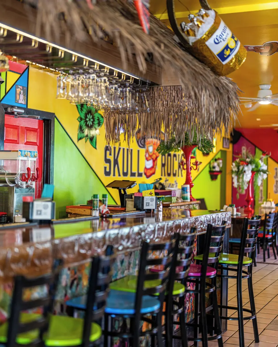 Skull Rock bar with colorful walls and high stools at Ports of Call Resort.
