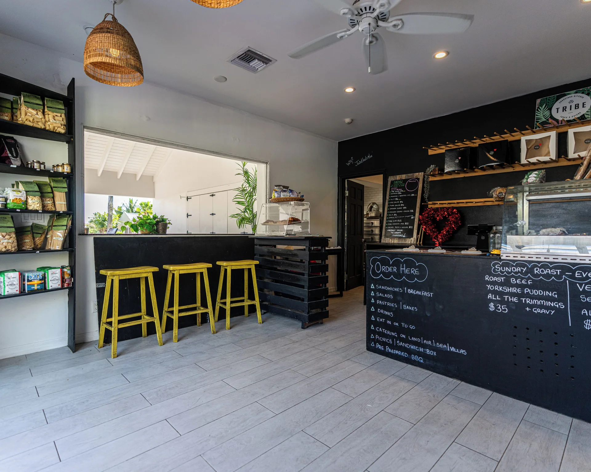 Tribe deli counter with shelves, stools, and chalkboard menus at Ports of Call Resort.