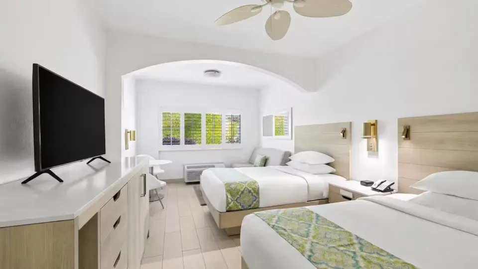 Family Suite 1 Bedroom with two beds, TV, and sitting area at Ports of Call Resort.
