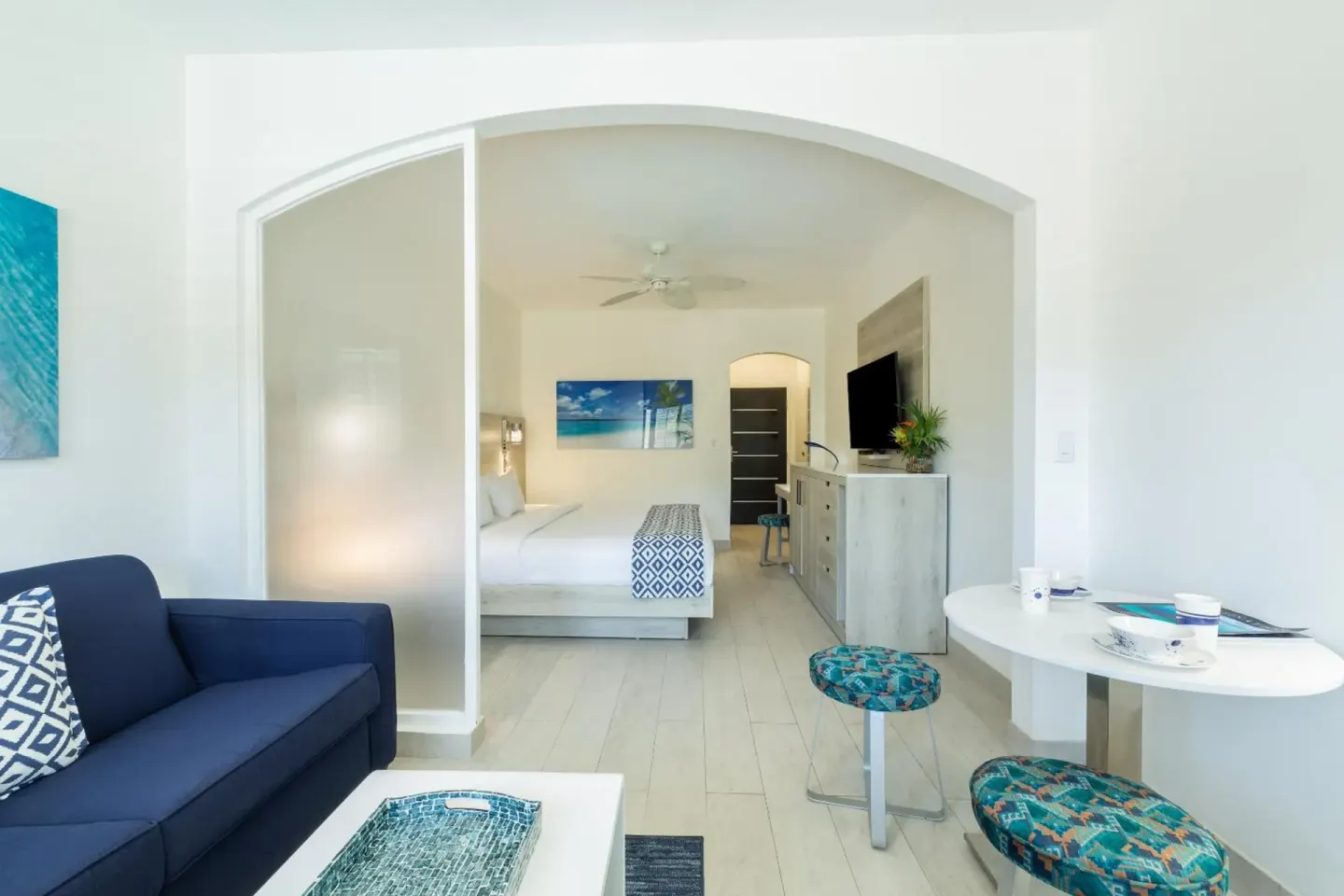 Suite living area with sofa, dining table, and king bed beyond at Ports of Call Resort.