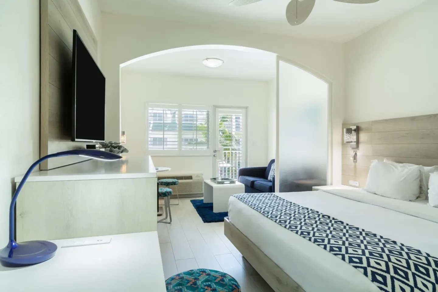 King guest room with balcony door, seating area, and TV at Ports of Call Resort.