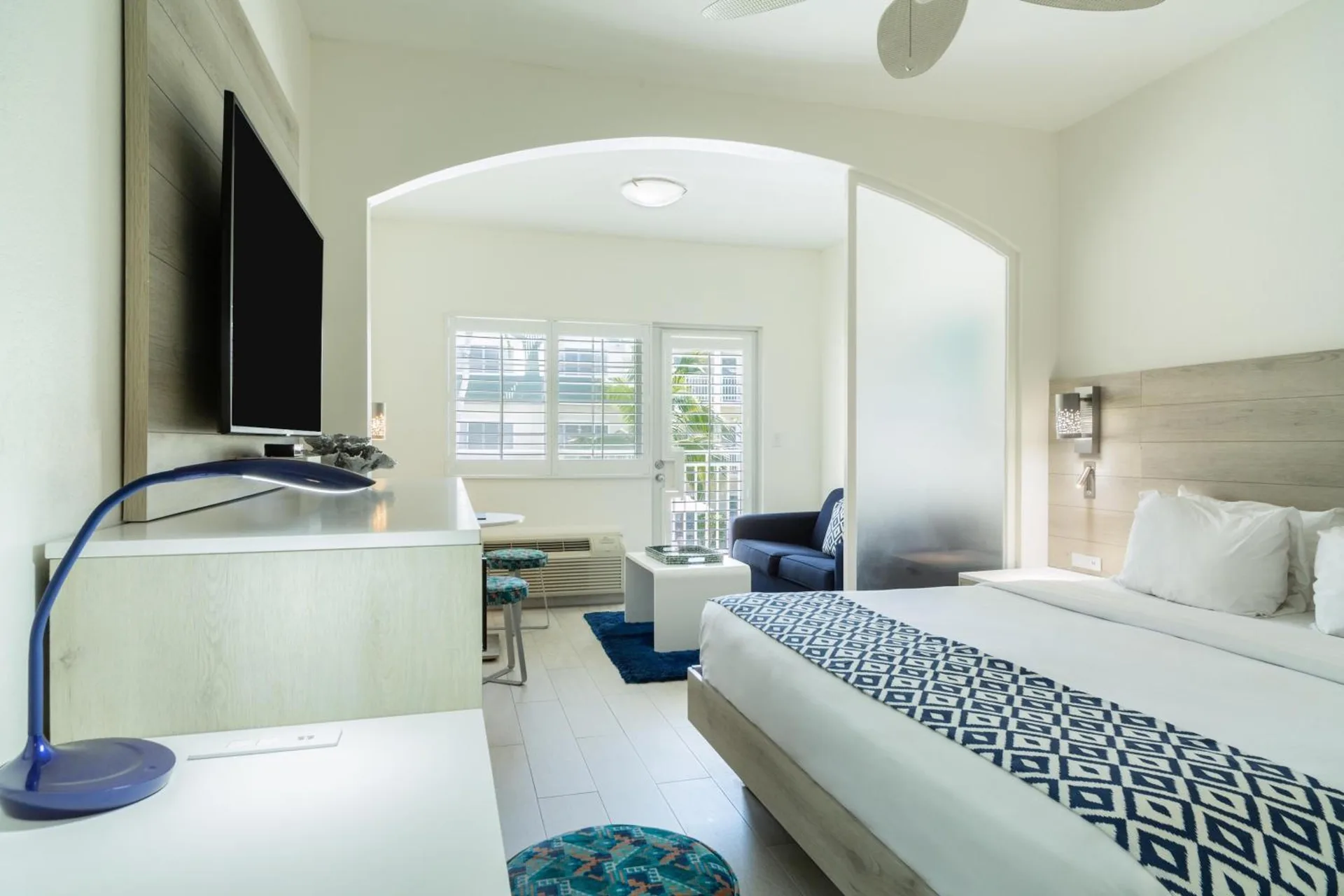 King guest room with balcony door, seating area, and TV at Ports of Call Resort.