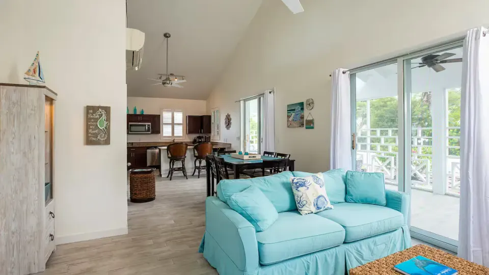 One Bedroom Suite living area with turquoise sofa and kitchenette at Ports of Call Resort.