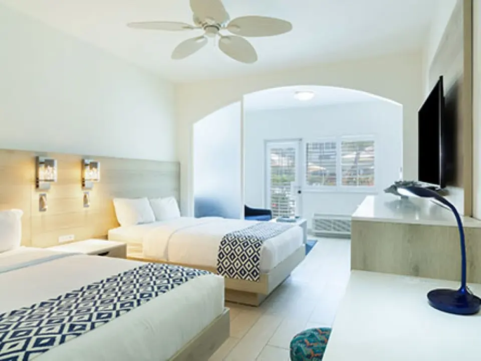 Three-bedroom villa guest room with two beds and seating area at Ports of Call Resort.