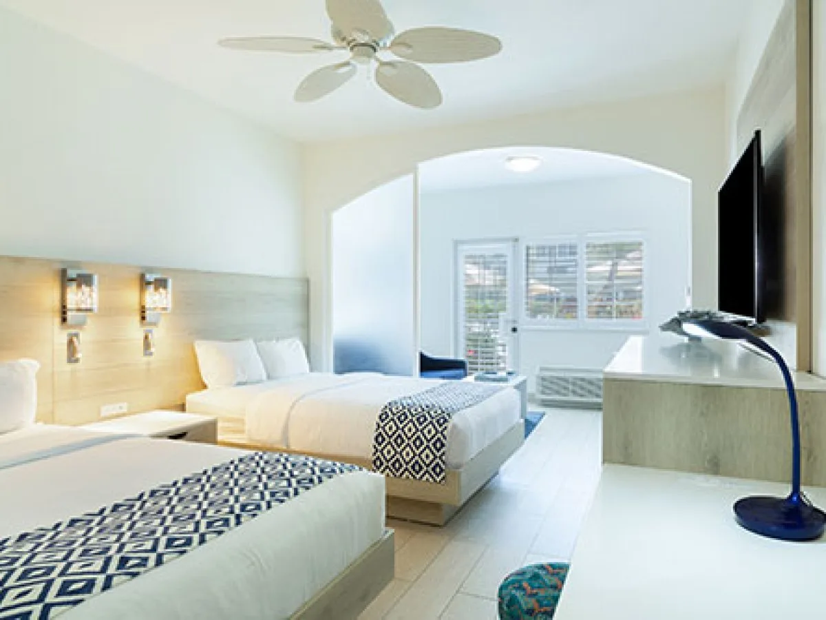 Three-bedroom villa guest room with two beds and seating area at Ports of Call Resort.