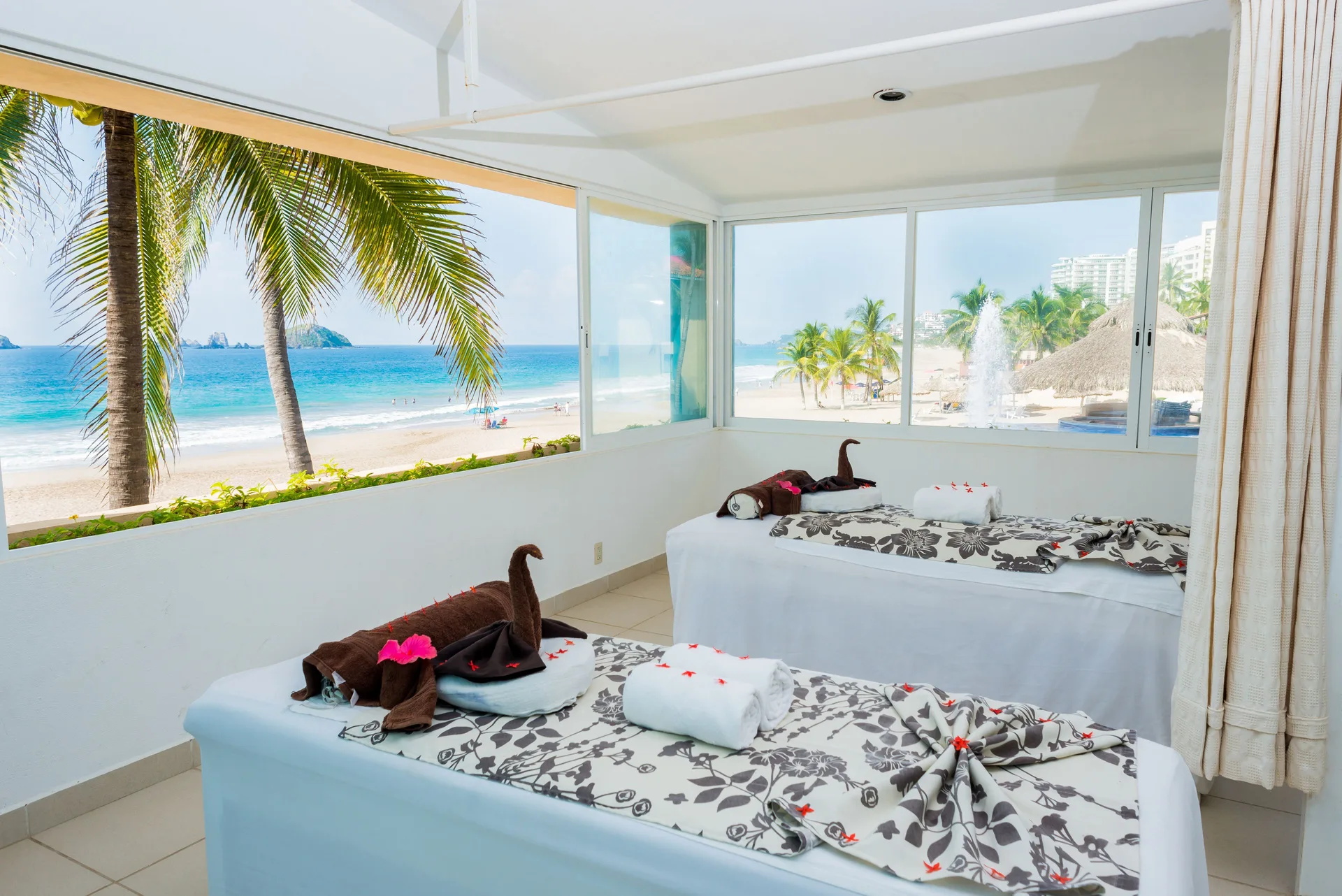 Two massage tables with towel art overlook the beach at Posada Real Ixtapa.