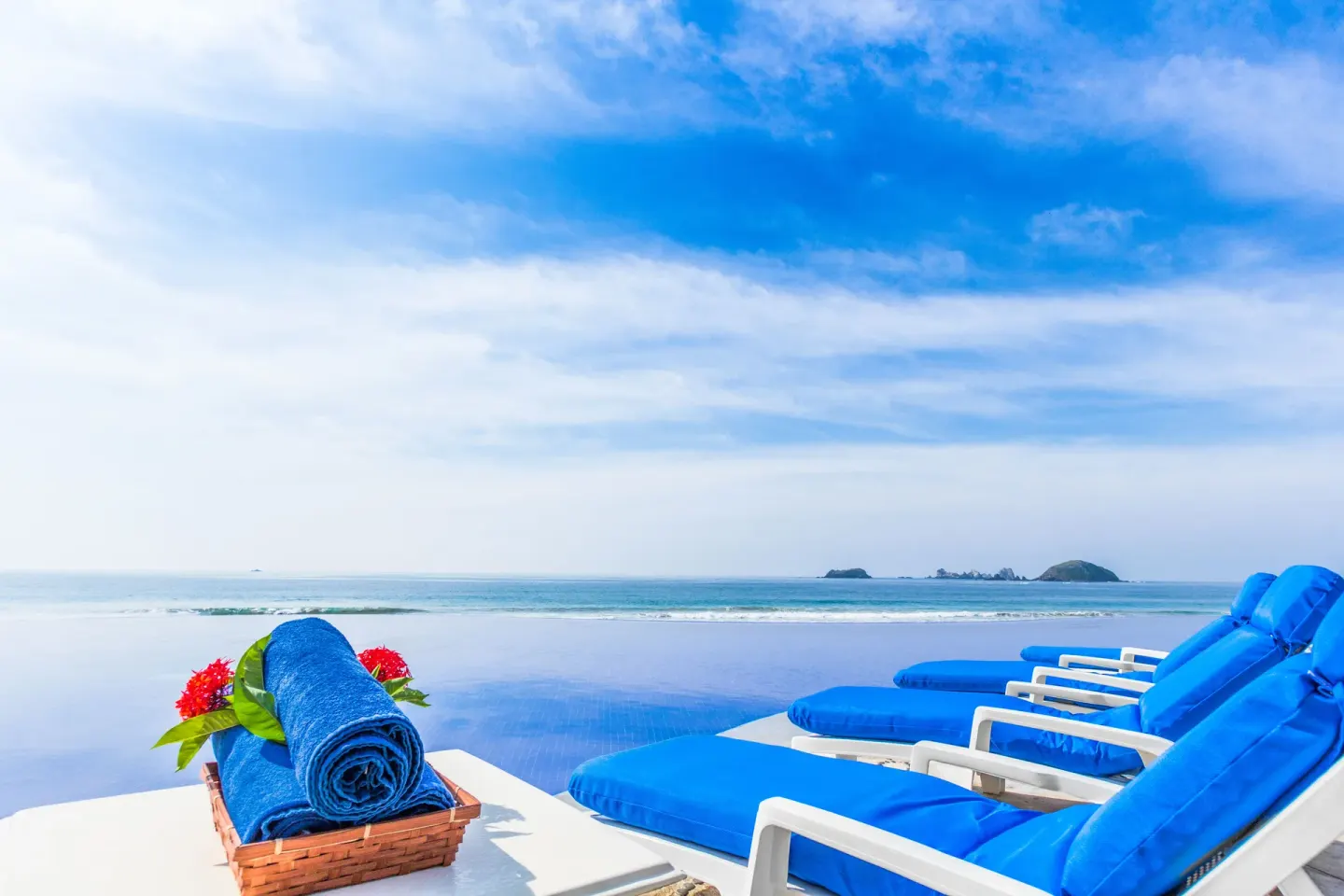 Poolside loungers and a towel basket face the Pacific at Posada Real Ixtapa.