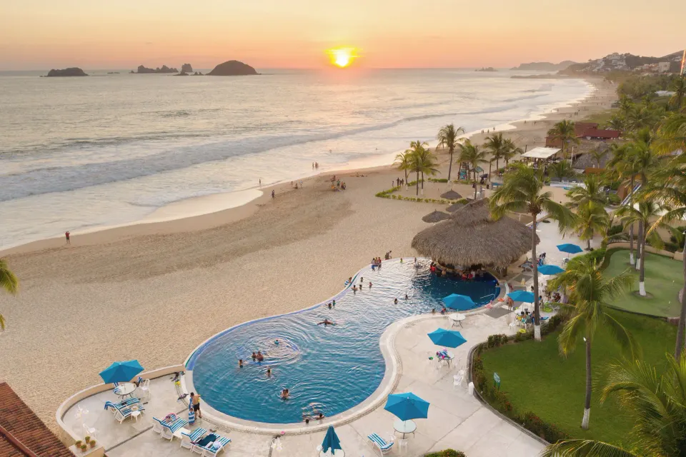 Terrace view of the pool, beach and sunset from Posada Real Ixtapa.