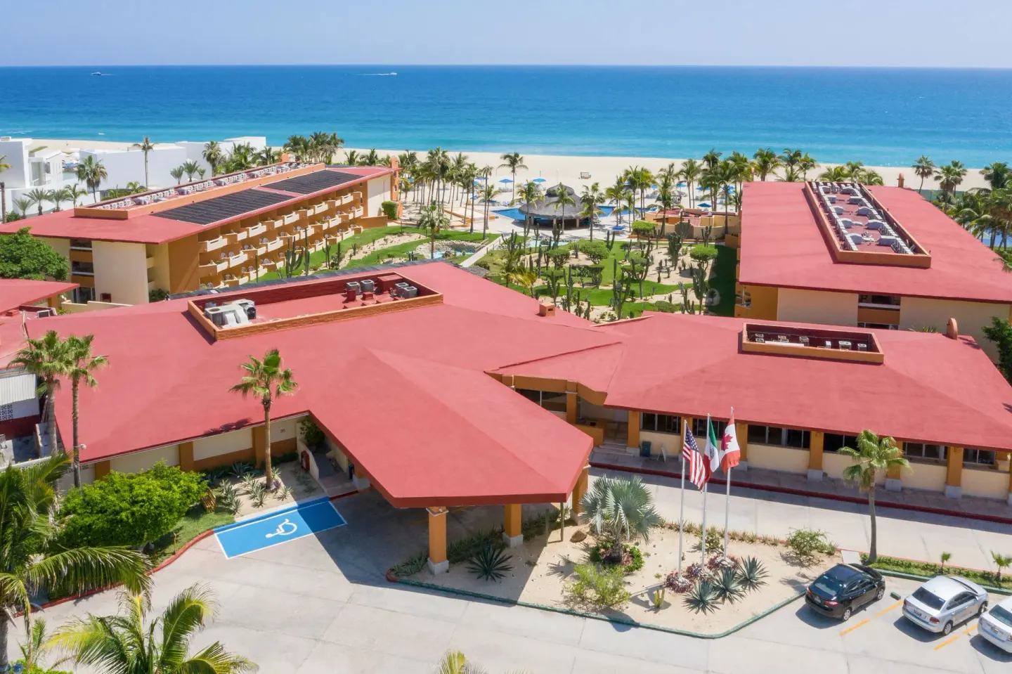 Aerial view of red-roofed resort buildings and the beach at Posada Real Los Cabos.