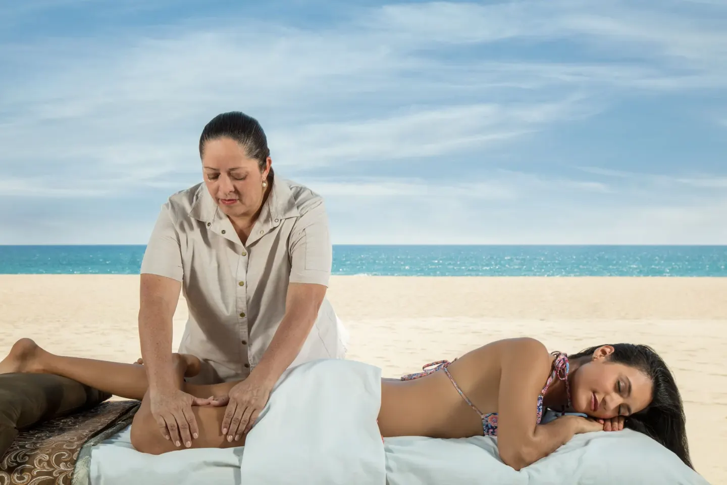 Therapist giving a beach massage by the ocean at Posada Real Los Cabos.