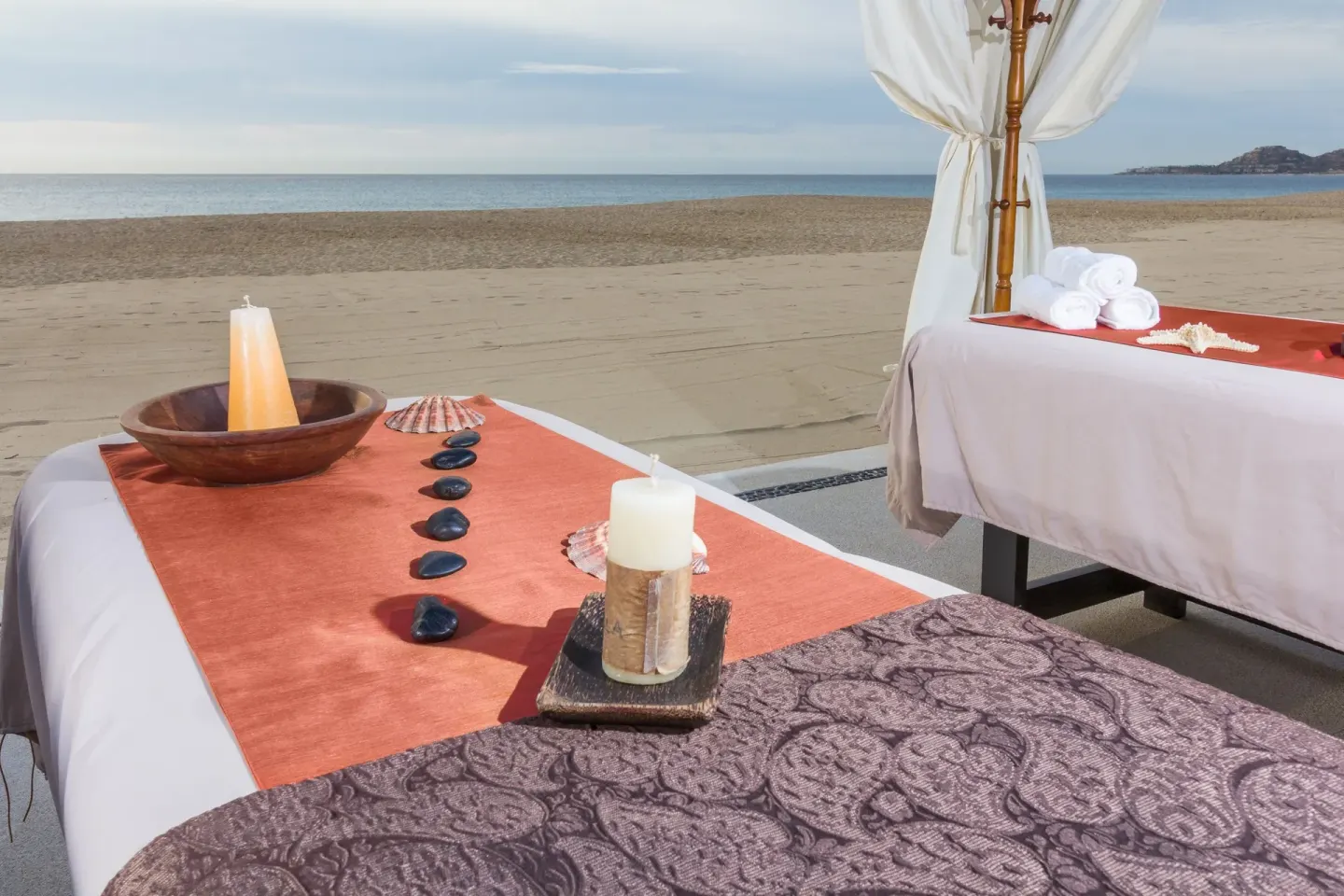 Beach massage tables with candles and towels at Posada Real Los Cabos.