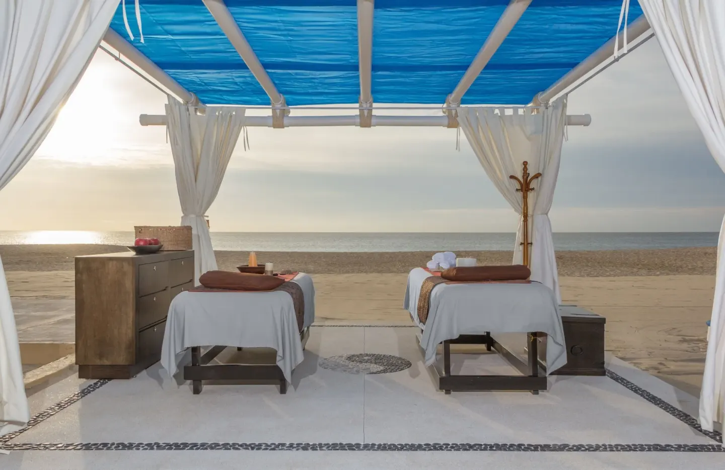 Two beach massage tables under a blue canopy at Posada Real Los Cabos.