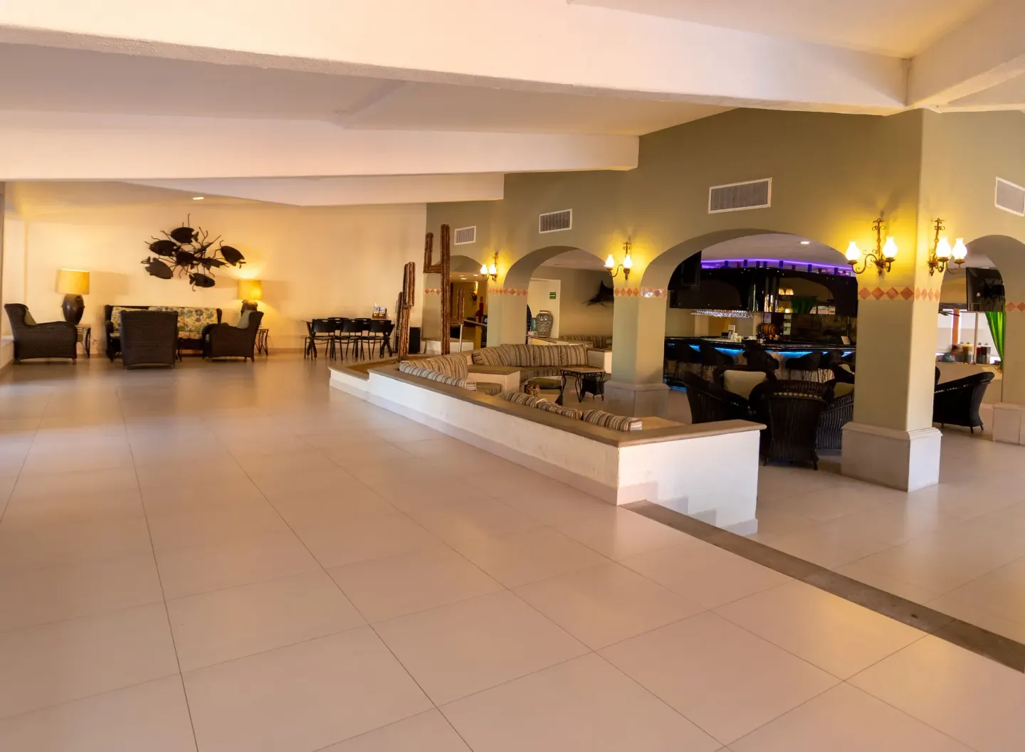Open lobby lounge with arched bar area and seating at Posada Real Los Cabos.