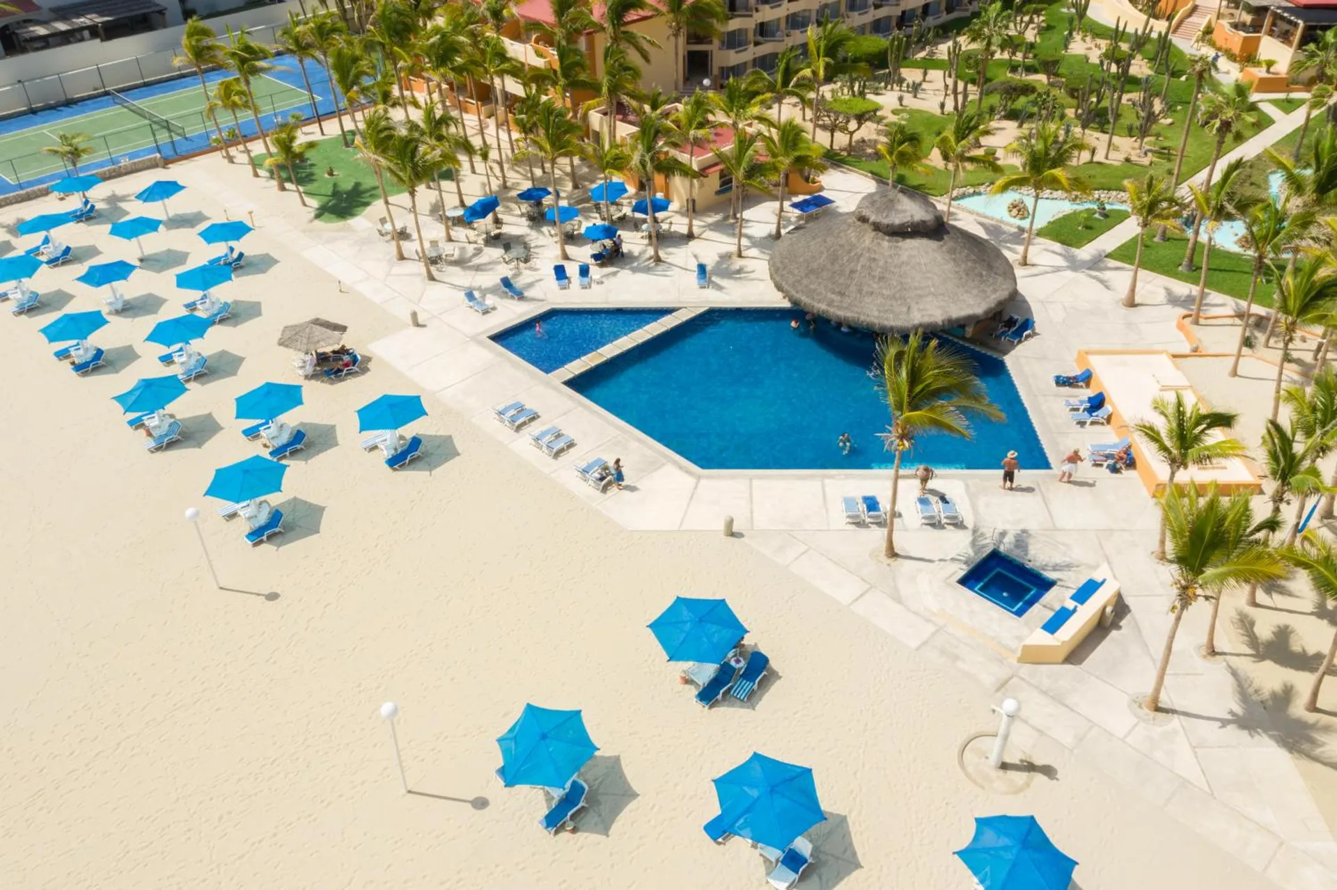 Aerial view of the pool, palapa bar, loungers, and umbrellas at Posada Real Los Cabos.