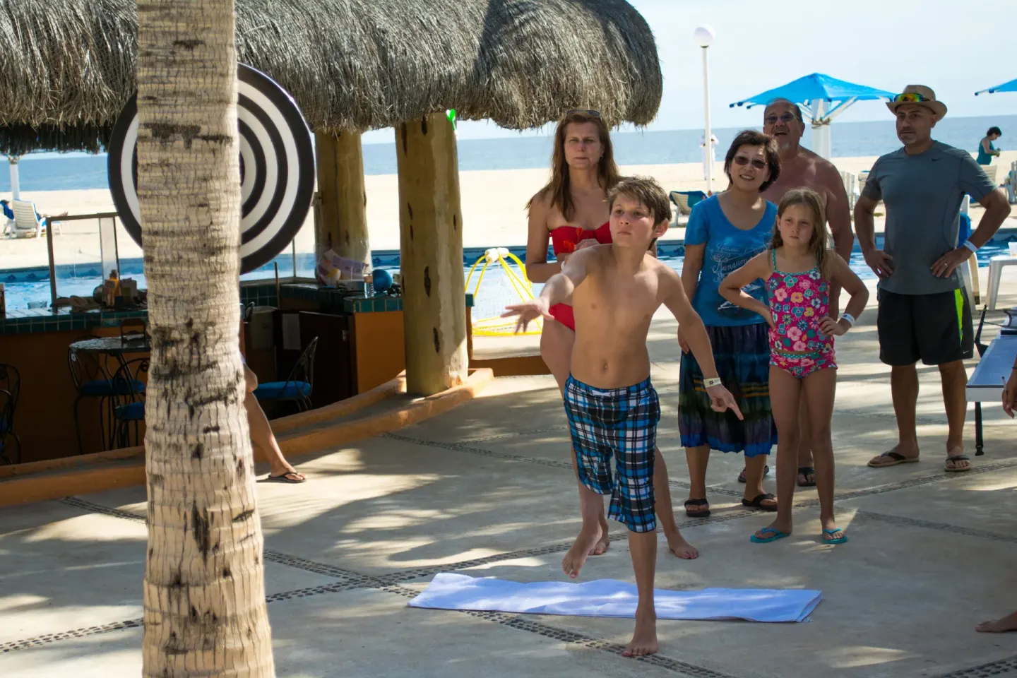 Guests playing a beanbag toss game near the pool at Posada Real Los Cabos.
