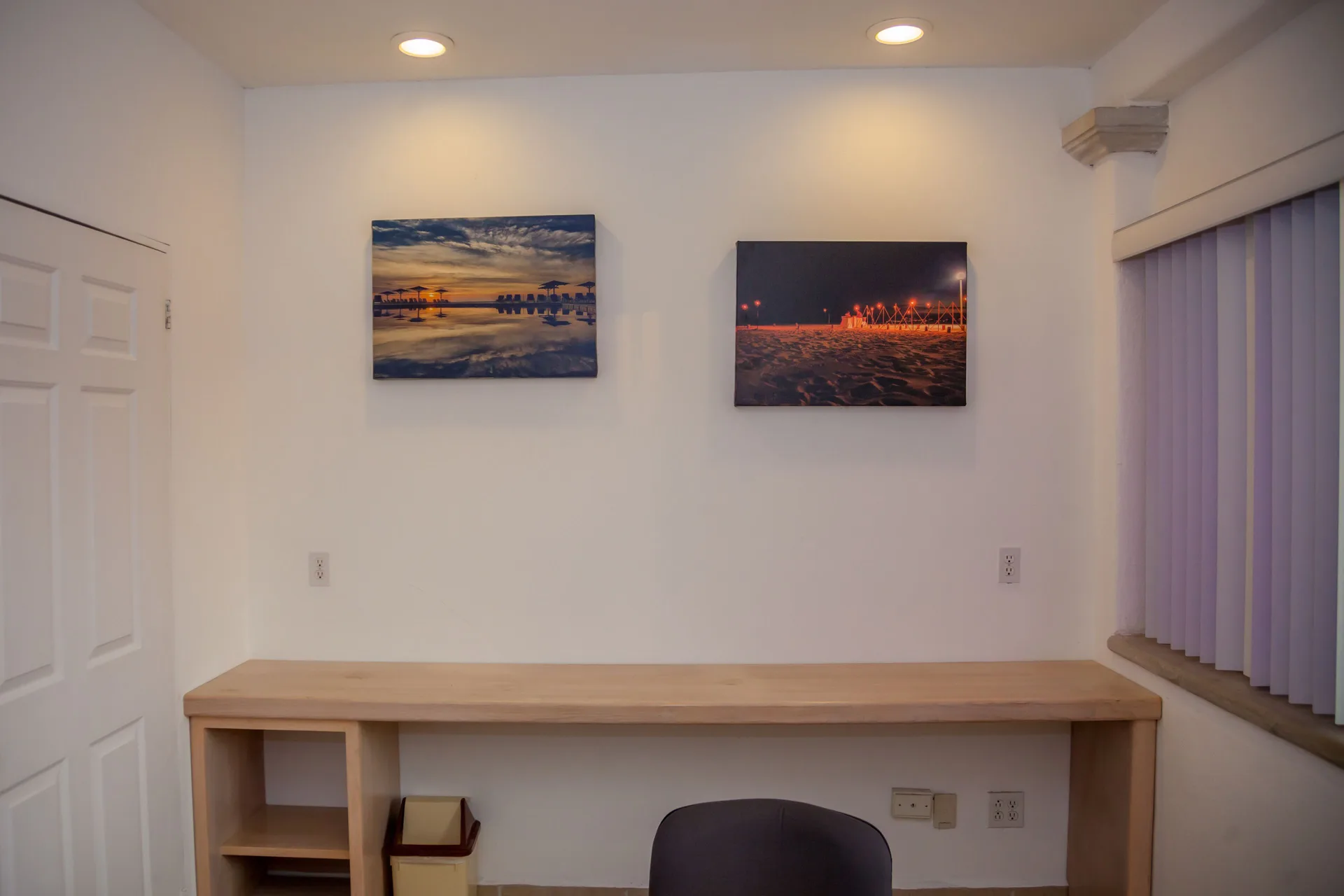 Meeting room wall with a long counter, chair and framed beach photos at Posada Real Los Cabos.
