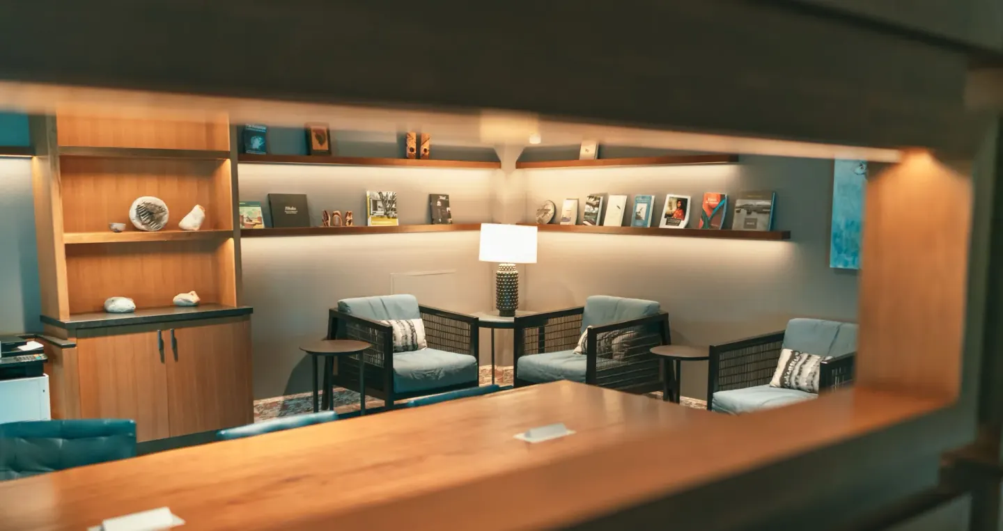 Quiet lounge seating area with shelves and armchairs at Prince Waikiki.