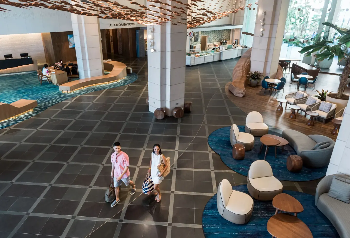 Open lobby with seating areas and guests walking through Prince Waikiki.