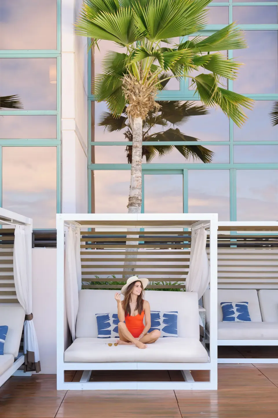 Poolside cabana with a guest seated beneath a palm at Prince Waikiki.