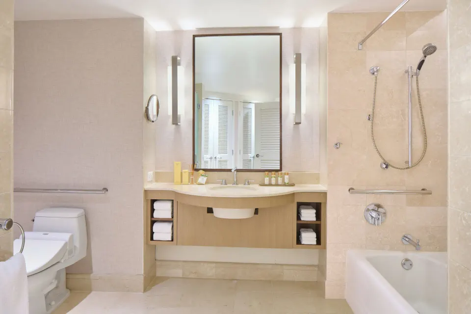 Accessible Ocean Front Harbor bathroom with tub, grab bars, vanity, and toilet at Prince Waikiki.