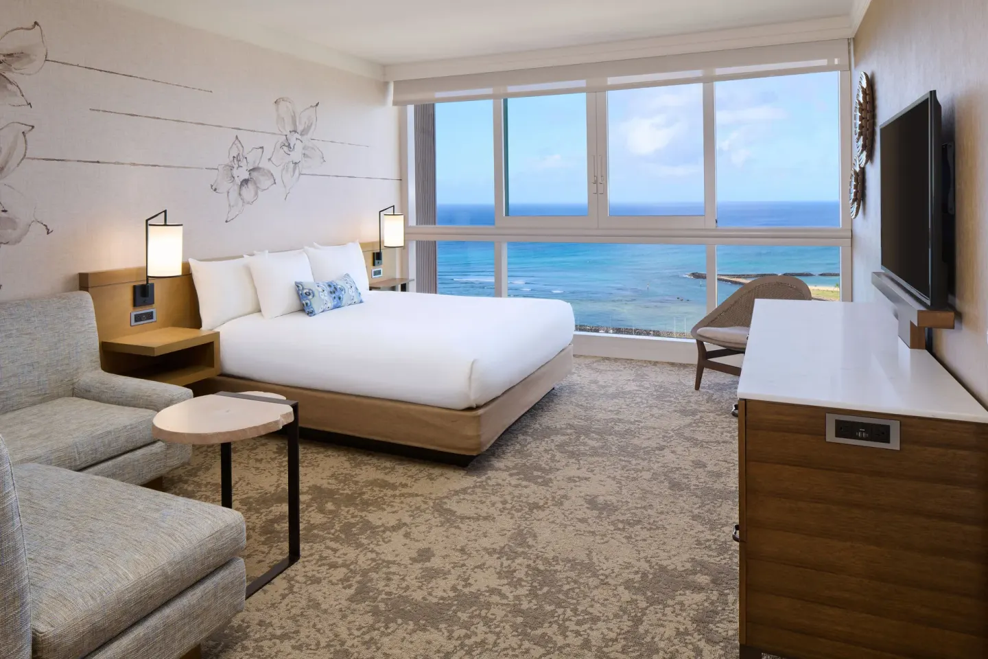 Ocean Front 1 Bedroom Suite bedroom with king bed, seating, TV, and ocean view at Prince Waikiki.
