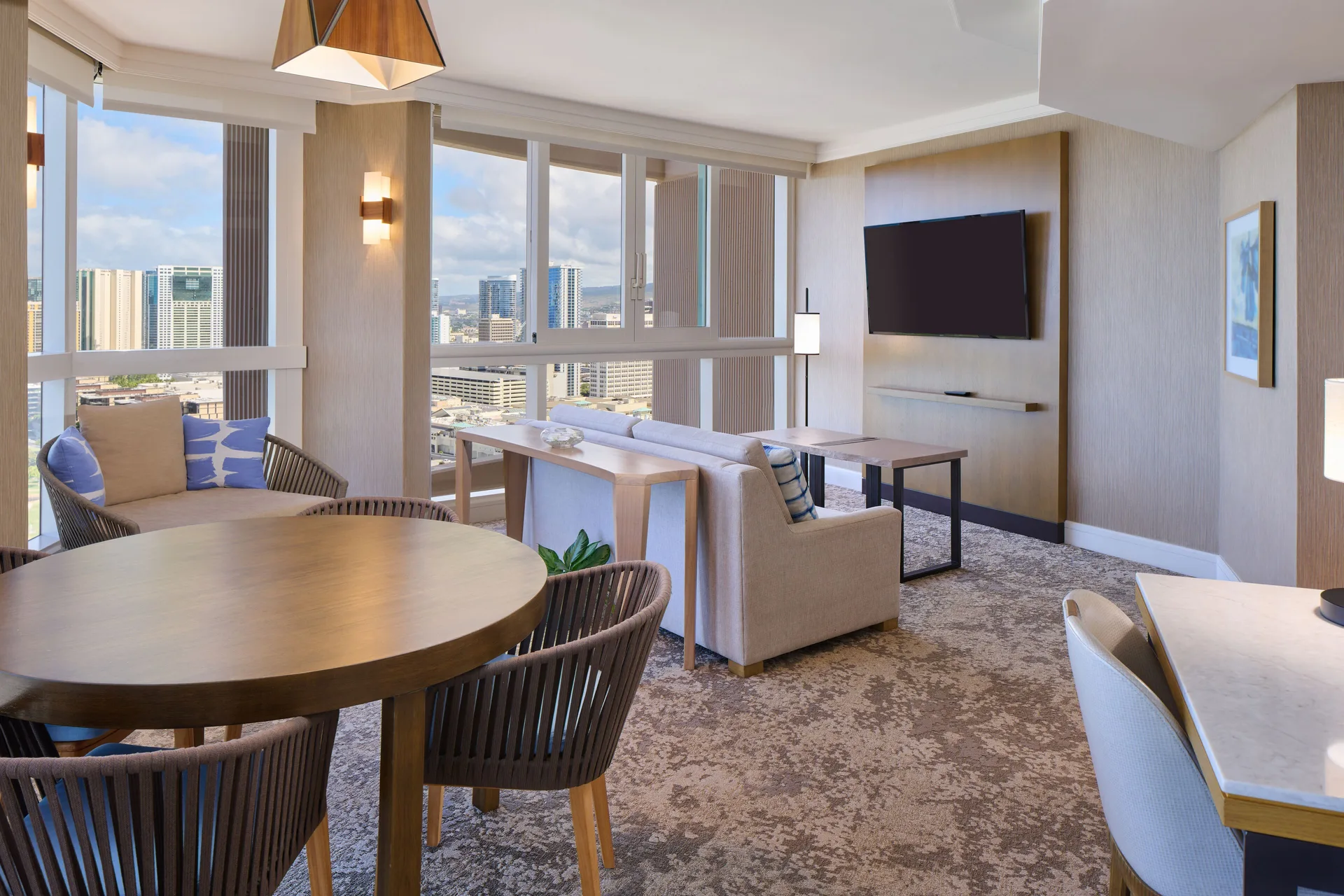 Ocean Front 1 Bedroom Suite living room with dining table and city views at Prince Waikiki.
