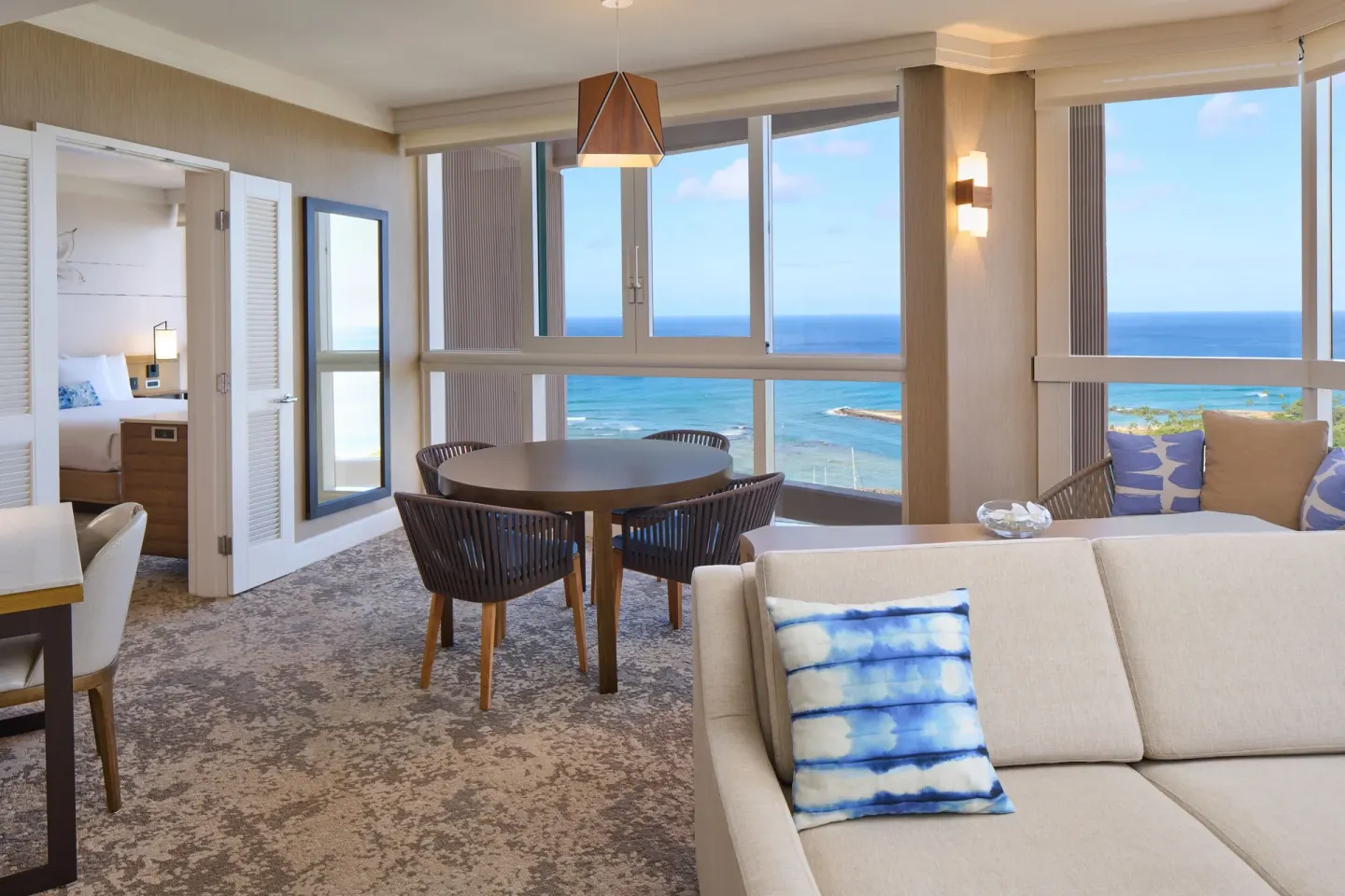 Ocean Front 1 Bedroom Suite living room with dining table and ocean windows at Prince Waikiki.