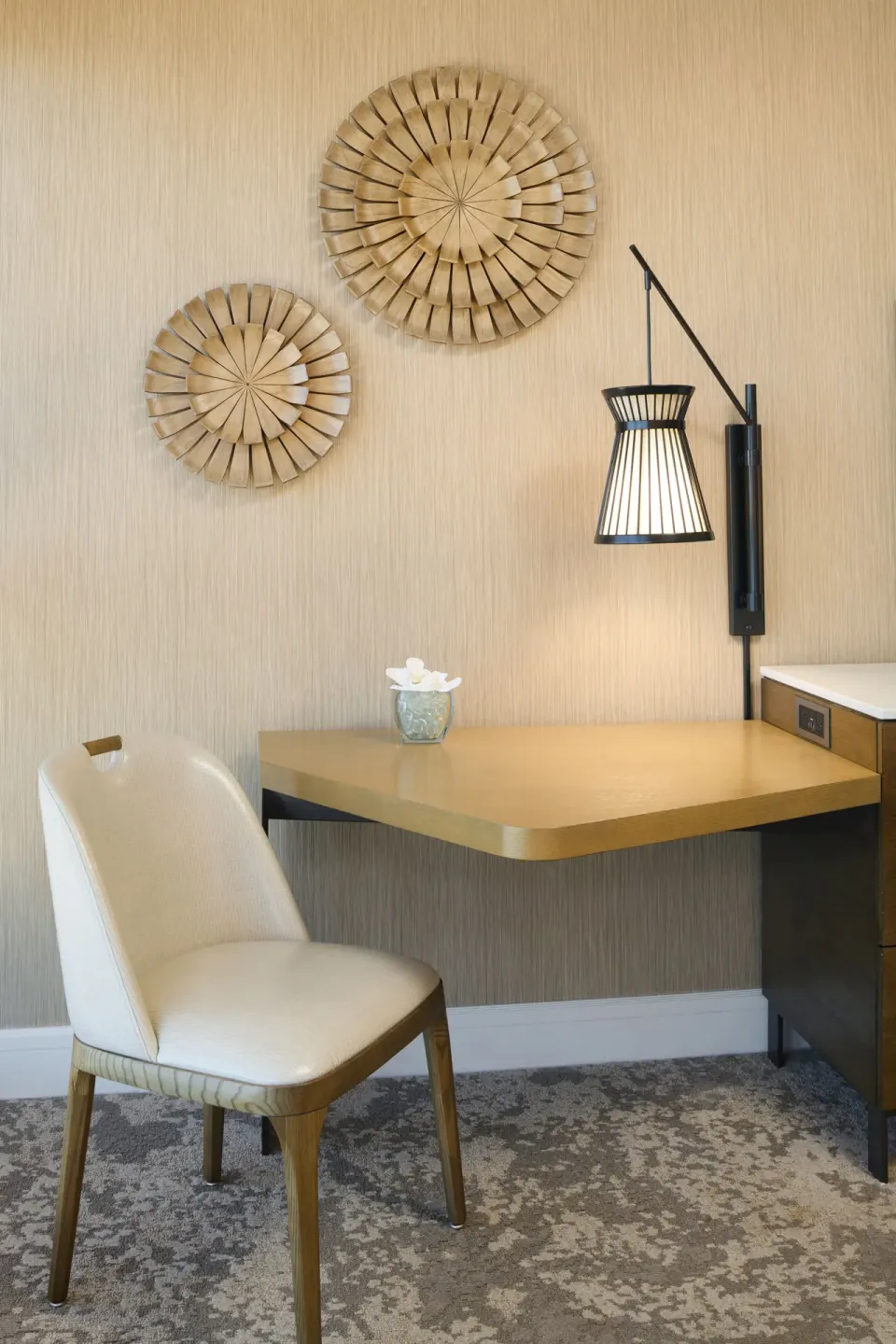 Ocean Front Harbor desk area at Prince Waikiki with chair, wall lamp, and circular wood wall decor.