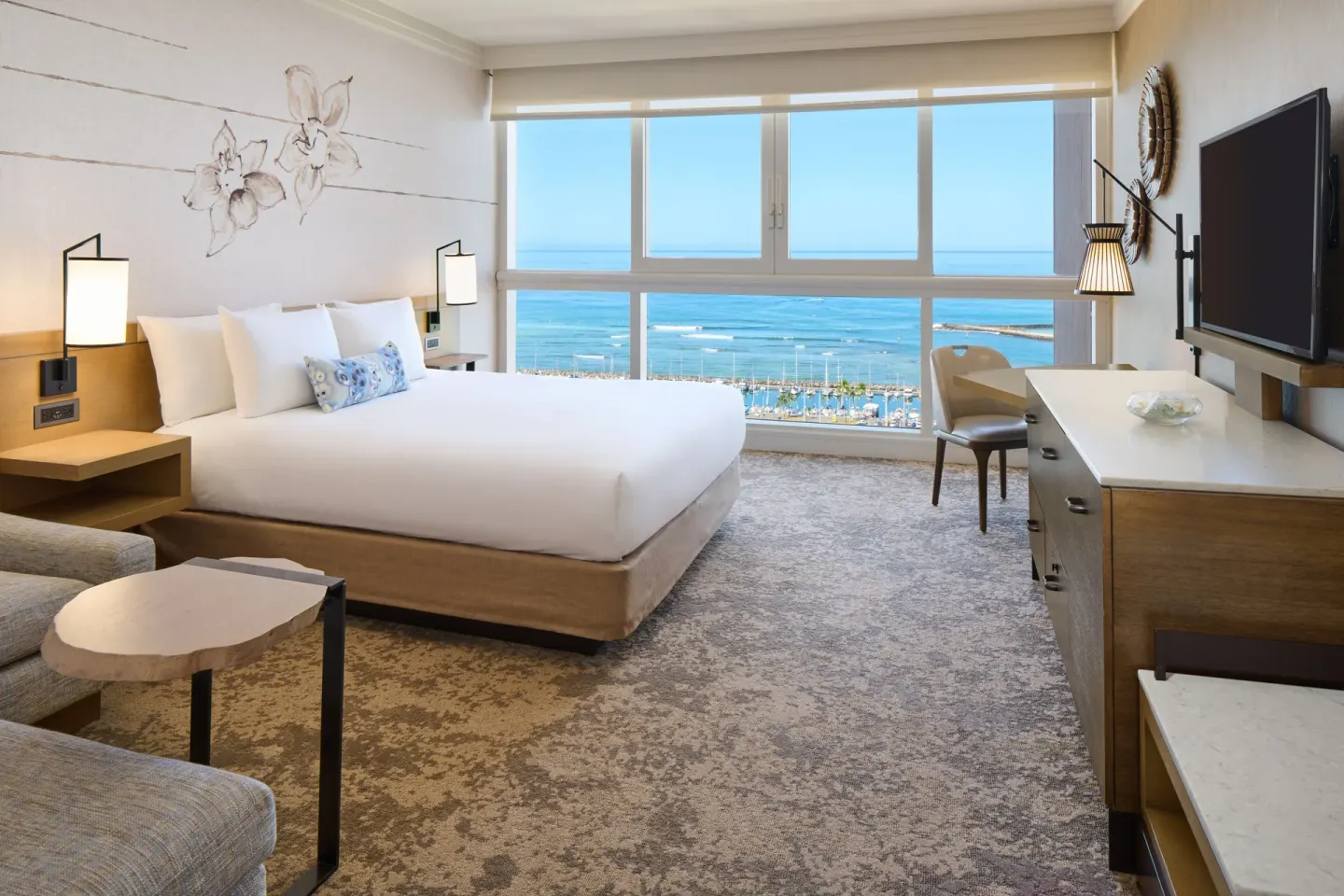 Ocean Front Harbor king room at Prince Waikiki with a bed, seating area, TV, and ocean-facing windows.