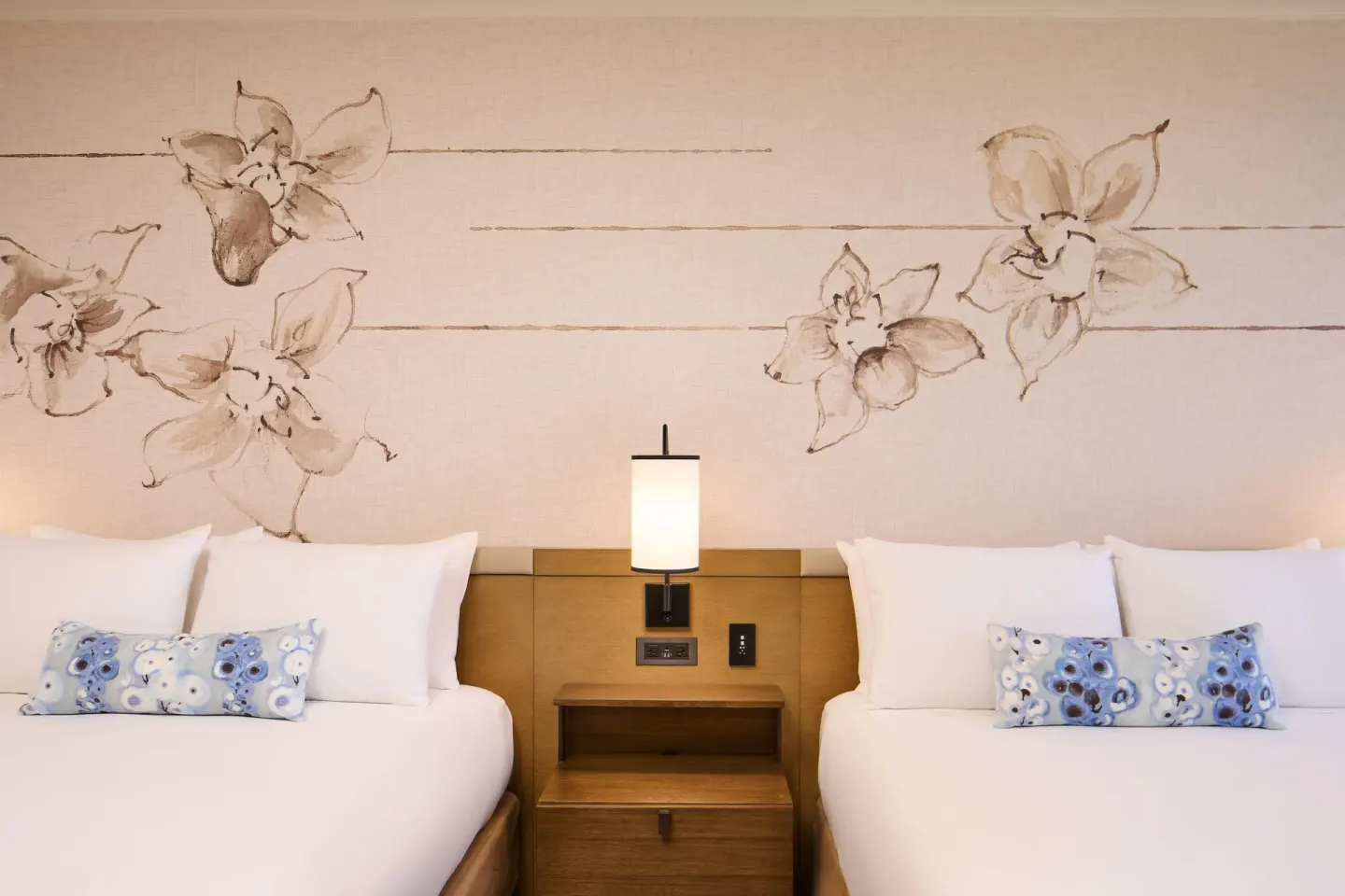 Two-bed Ocean Front Premier room with floral wall art at Prince Waikiki.