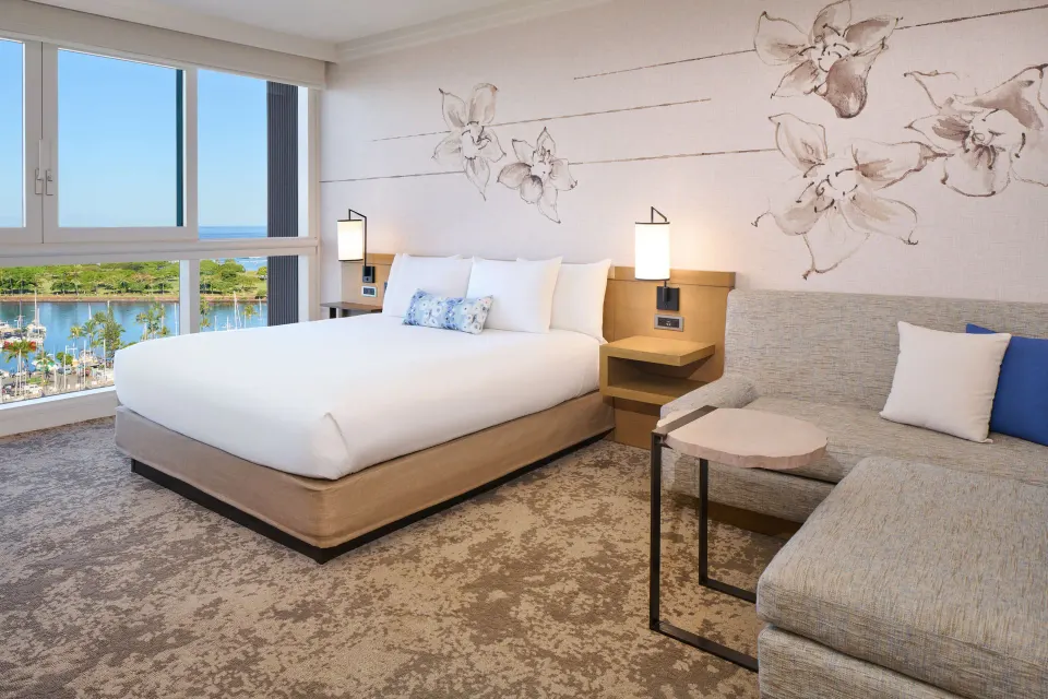 Ocean Front king bed with sofa and window view at Prince Waikiki.