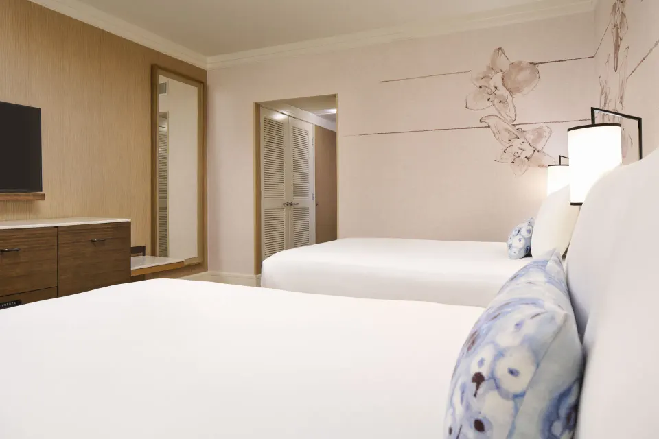 Ocean Front room with two beds, dresser, and mirror at Prince Waikiki.