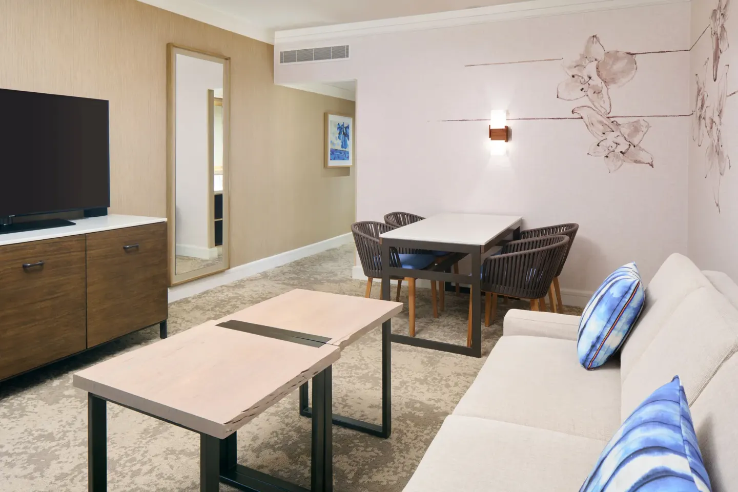 Ocean View Suite living area with sofa and dining table at Prince Waikiki.