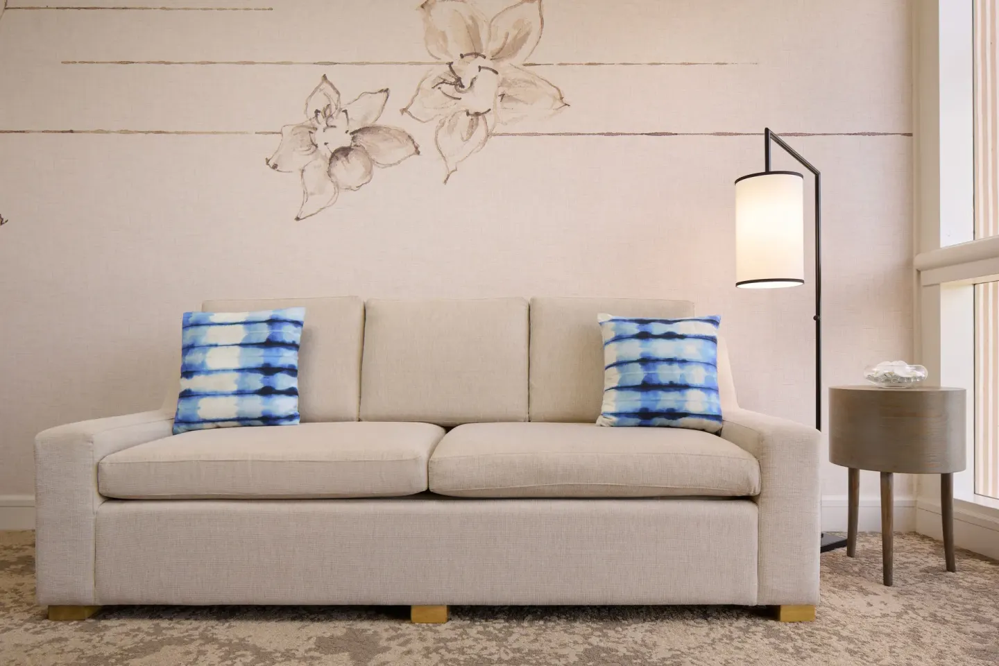 Ocean View Suite sofa with blue pillows and floor lamp at Prince Waikiki.