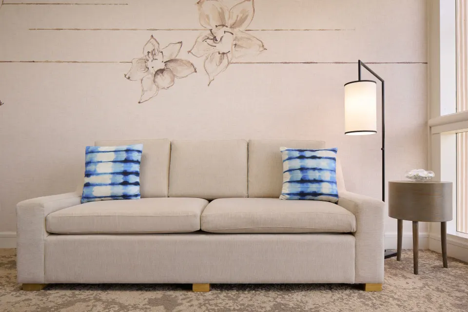 Ocean View Suite sofa with blue pillows and floor lamp at Prince Waikiki.