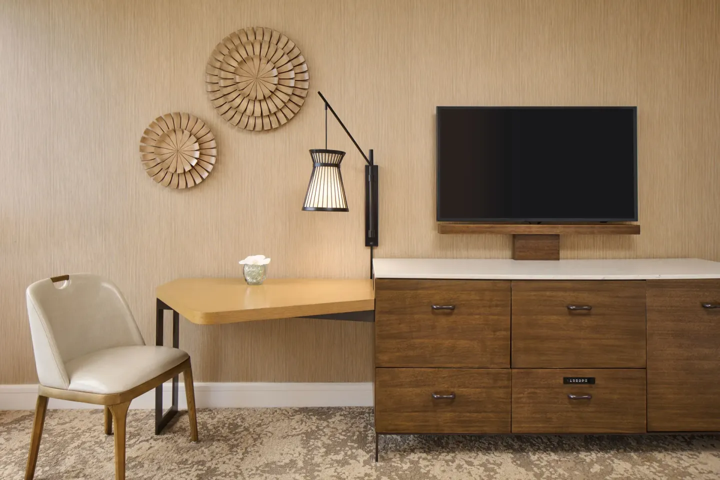 Ocean View room desk, chair, dresser, TV, lamp, and wall decor at Prince Waikiki.