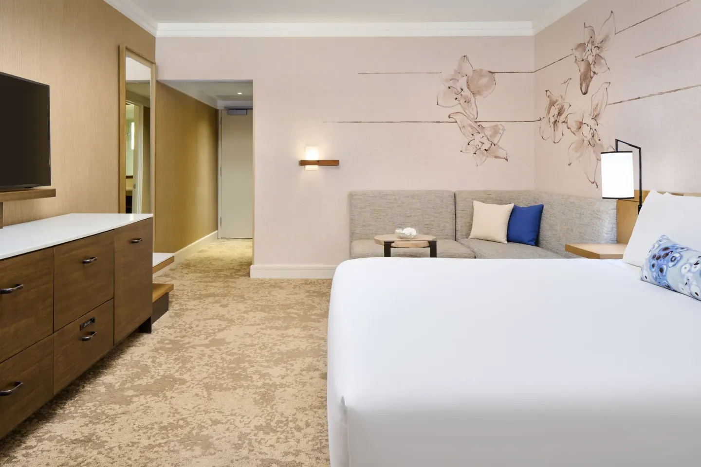Ocean View room with king bed, sofa, dresser, TV, and floral wall art at Prince Waikiki.