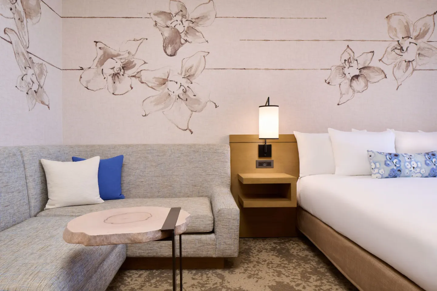 Ocean View room sofa, king bed, floral wall art, and bedside lamp at Prince Waikiki.