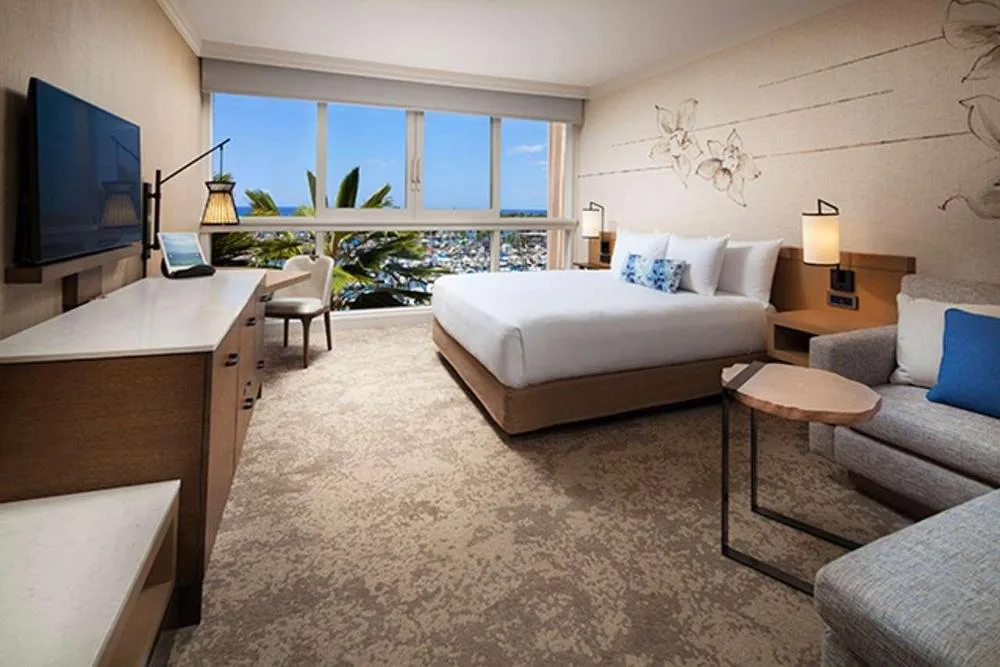Oceanfront Harbor View Room with king bed, sofa, and harbor view at Prince Waikiki.