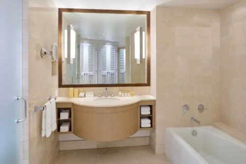 Premier Oceanfront Room bathroom vanity, mirror lights, and tub at Prince Waikiki.