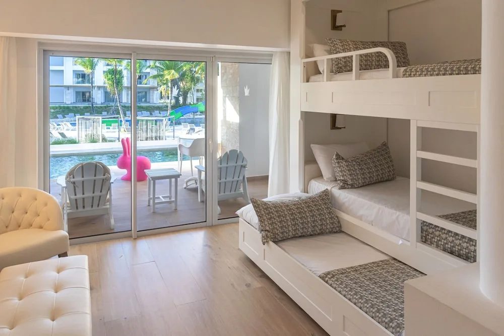 Family room bunk beds beside sliding doors to the pool at Princess Family Club Bavaro.