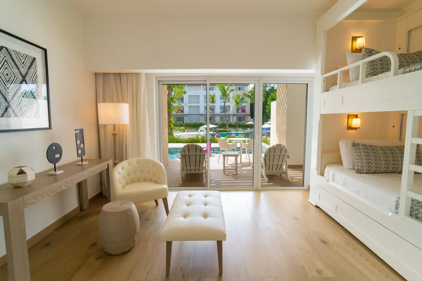 Family room seating area and bunk beds facing a pool patio at Princess Family Club Bavaro.