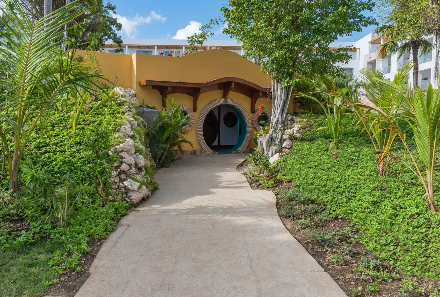 Curving garden path to a round doorway building at Princess Family Club Bavaro.