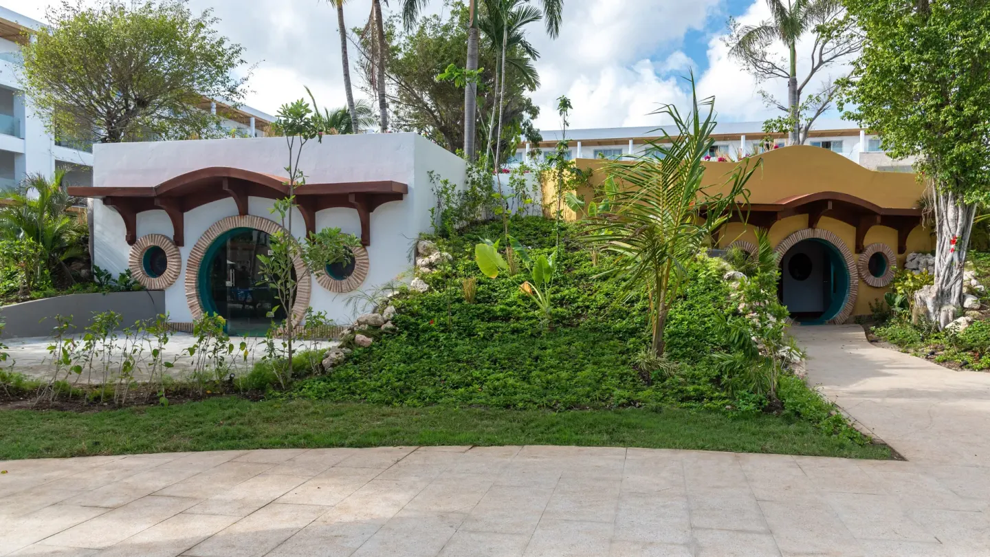 Garden walkway between playful round-door buildings at Princess Family Club Bavaro.