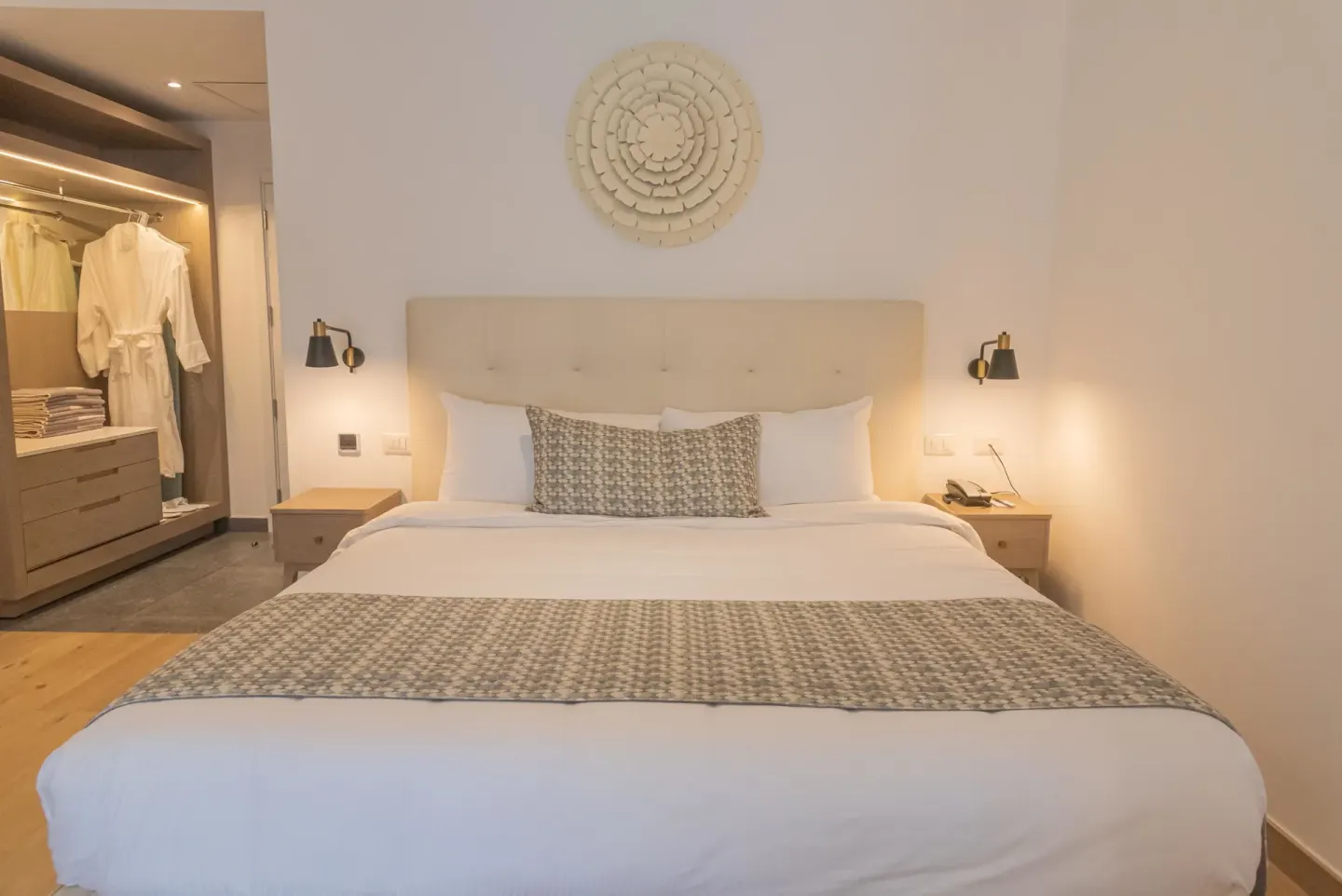 King bed guest room with bedside lamps and open wardrobe at Princess Family Club Bavaro.